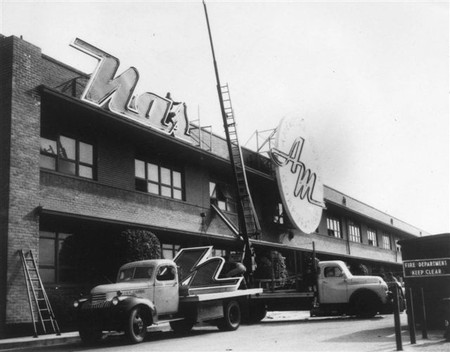 Workers remove signage from the Nash assembly plant after its closure in 1955. (Credit: allpar.com website)